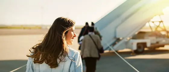 Een vrouw en een kind zijn op het vliegveld en kijken uit het raam naar het schort.