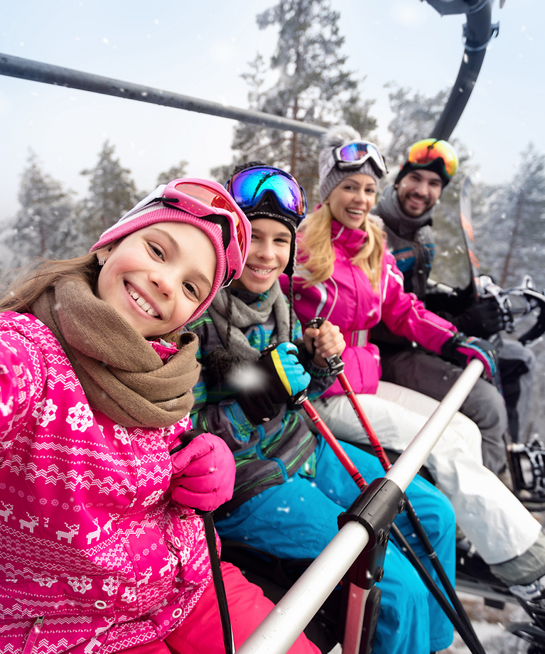 Een gezin ligt in de skilift en maakt een selfie.