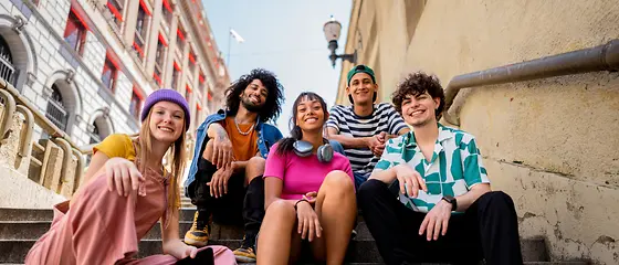 Een groep jongeren staat op een trap.